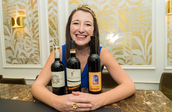 Die Deutsche Weinprinzessin Anna-Maria Löffler mit den Gewinnerweinen des ersten DWI-Sonderpreises für die besten Rotwein Cuvées 2020